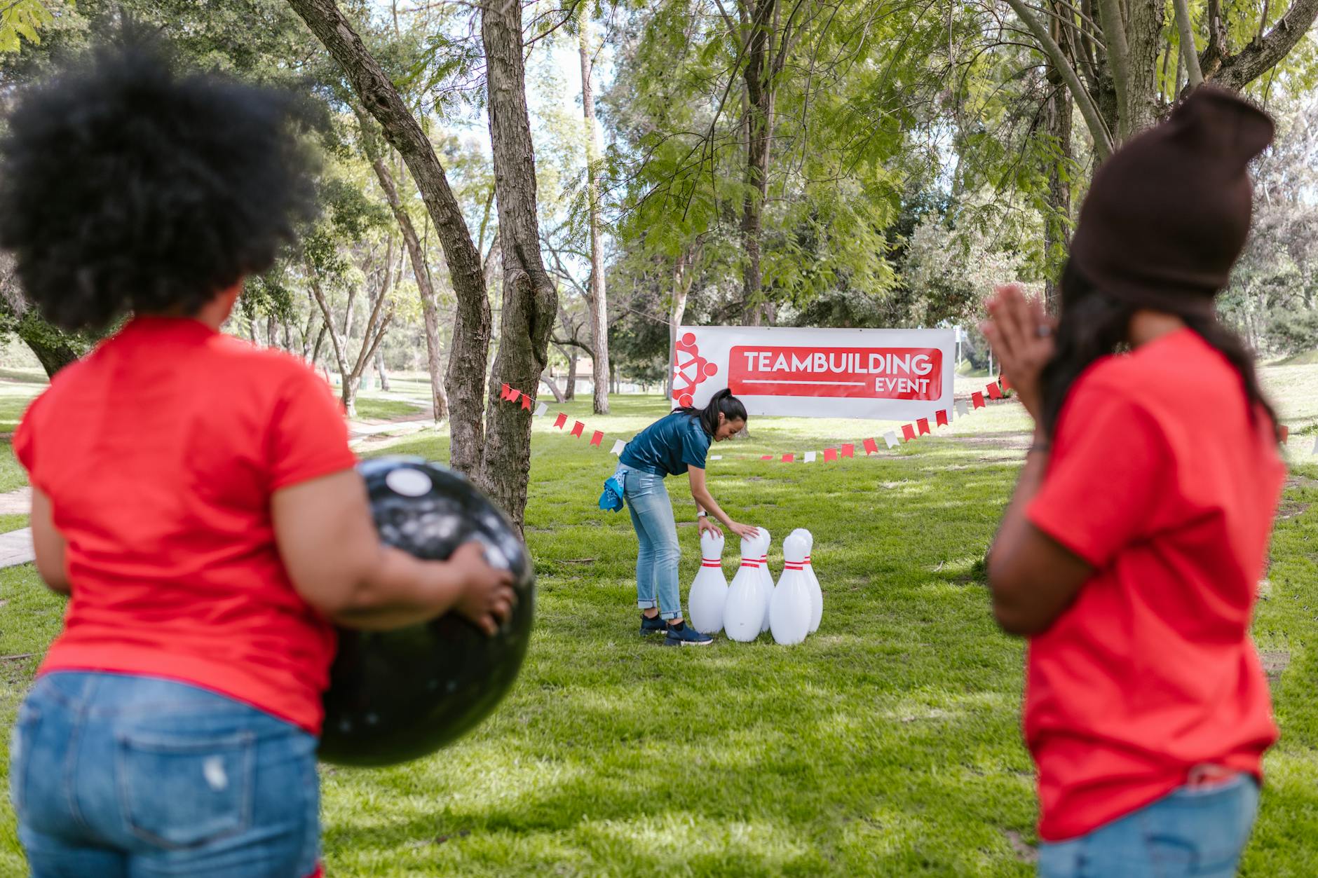 Group enjoying a fun outdoor team building bowling game at a park.